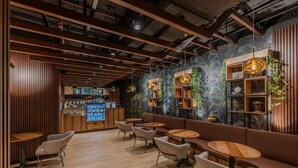 Een modern interieur met houten lambrisering, ronde tafels en een bar.