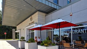 An outdoor seating area with tables and chairs, a stop sign, and a building with a 'CuB' sign. - Hotel Davídek (Trutnov)