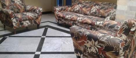 Una habitación con suelo a cuadros y sofás estampados con motivos florales.