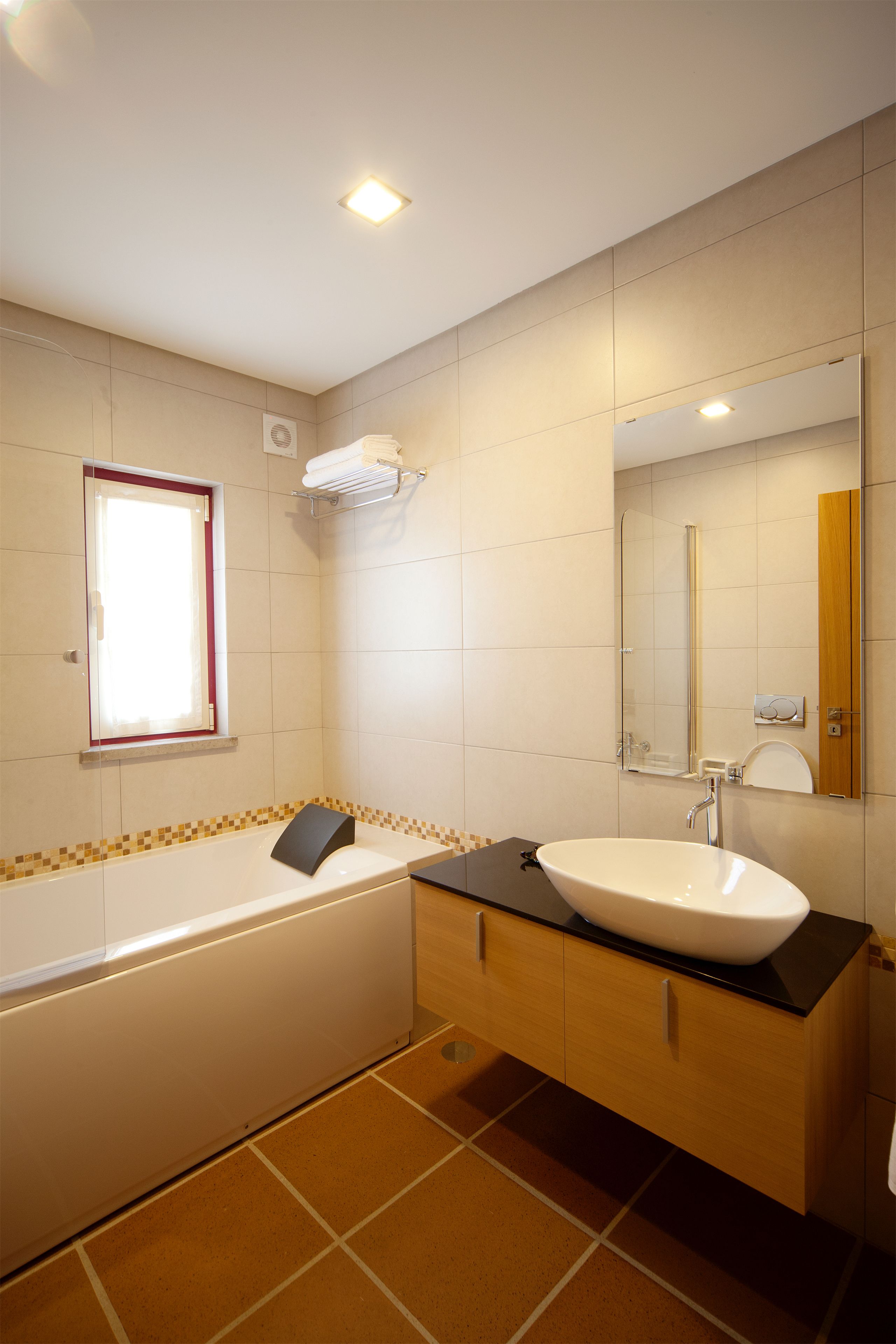 Un baño moderno con bañera, lavamanos y espejo.