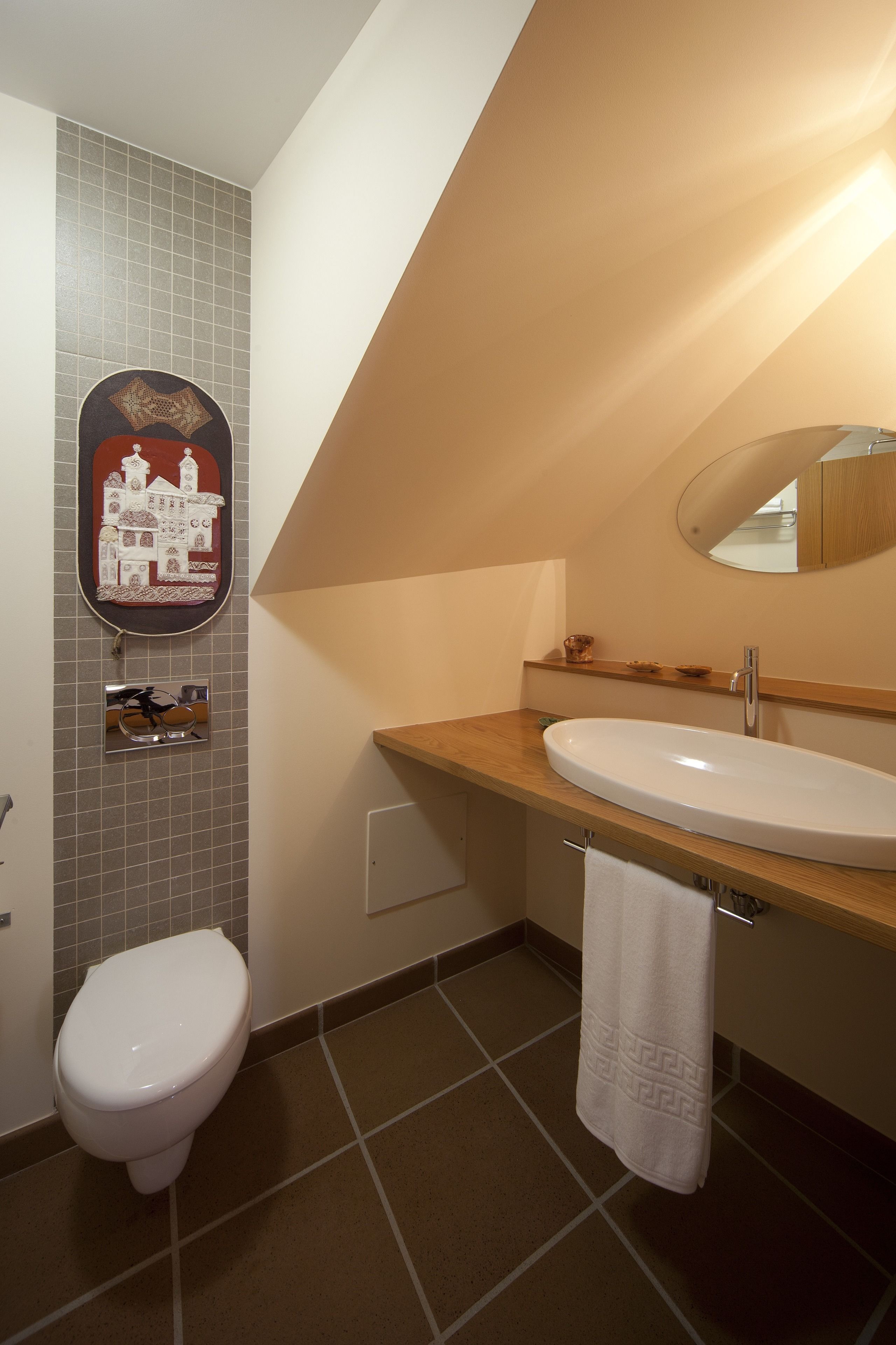 A bathroom with a toilet, sink, and mirror.