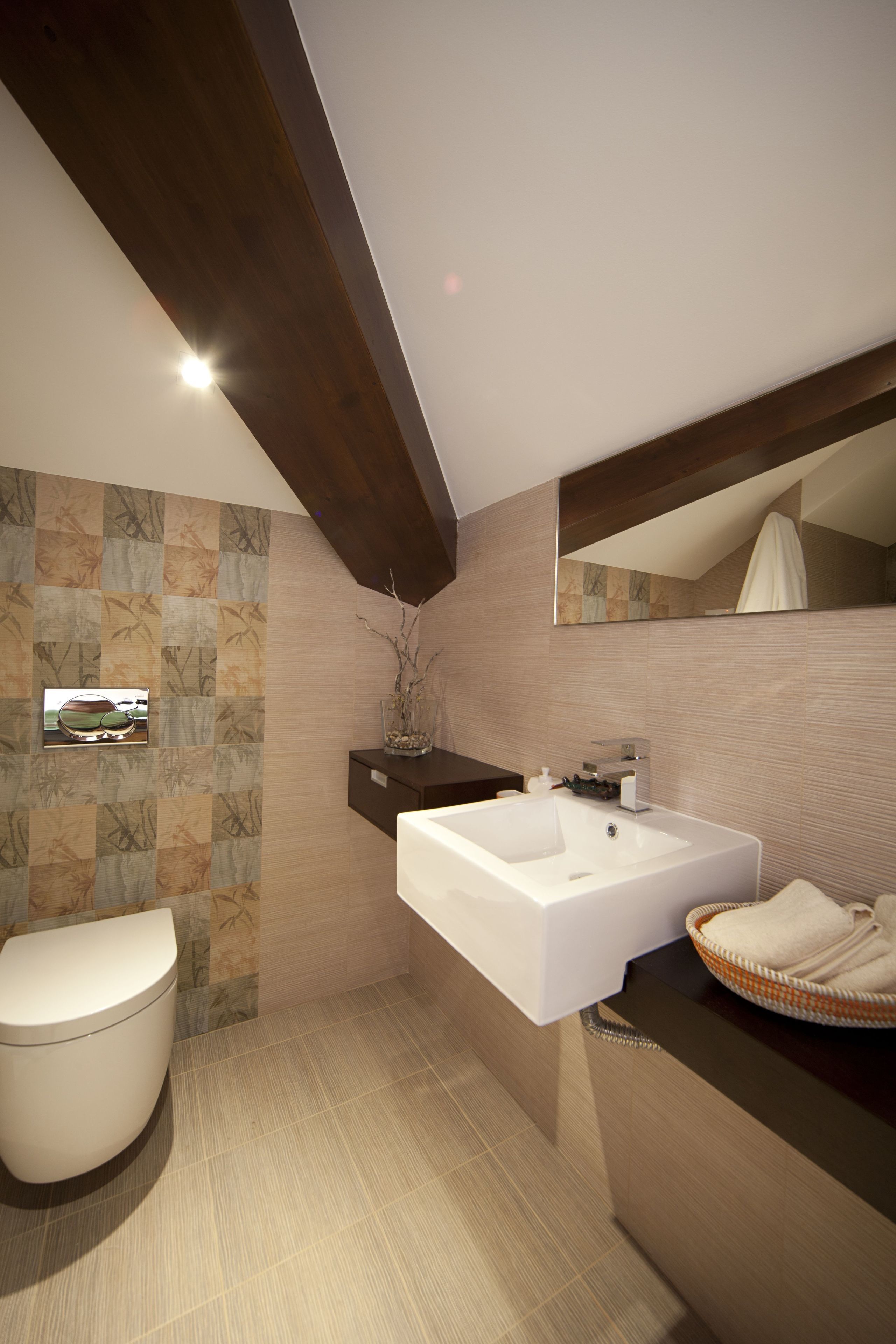 Un baño moderno con un lavamanos grande de color blanco, un inodoro y un espejo sobre el lavamanos.