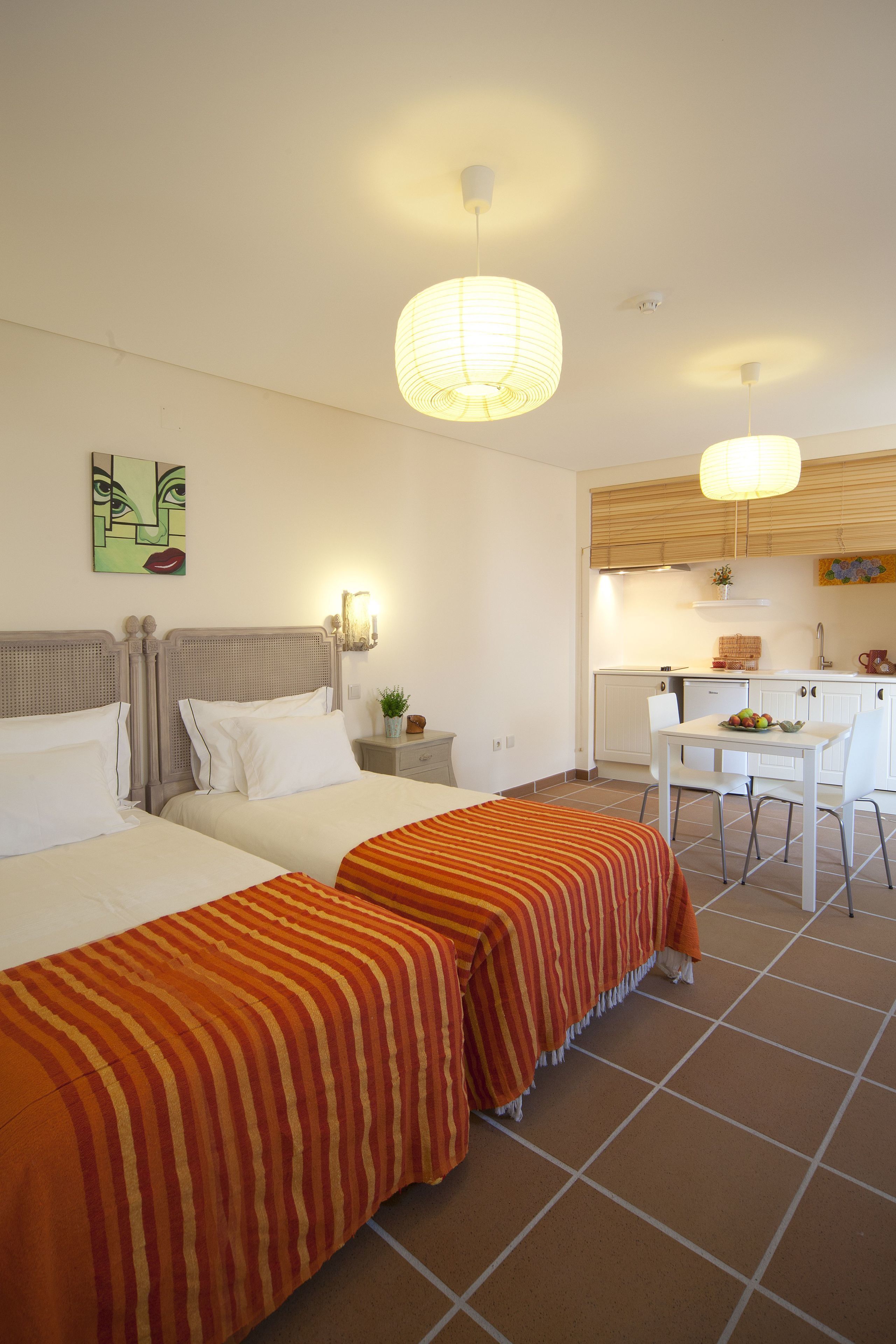 Une chambre d’hôtel avec deux lits, une petite kitchenette et un coin repas.