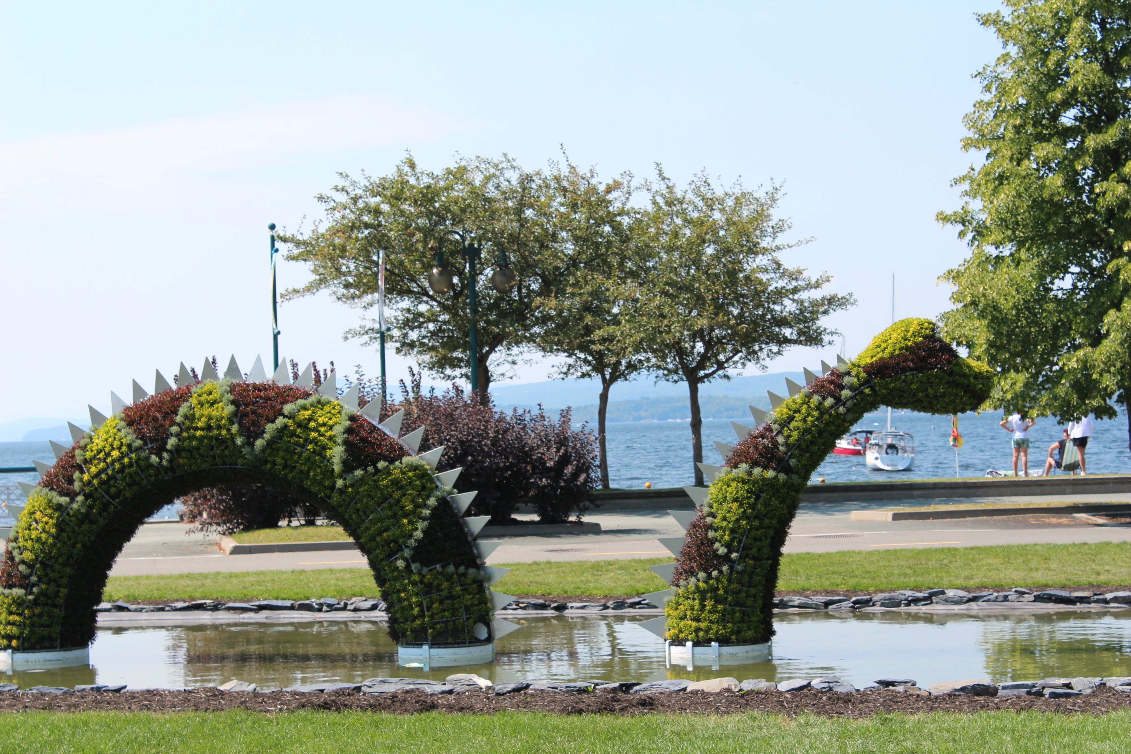 A landscaped area with a pond, decorative arches, and a view of the water.