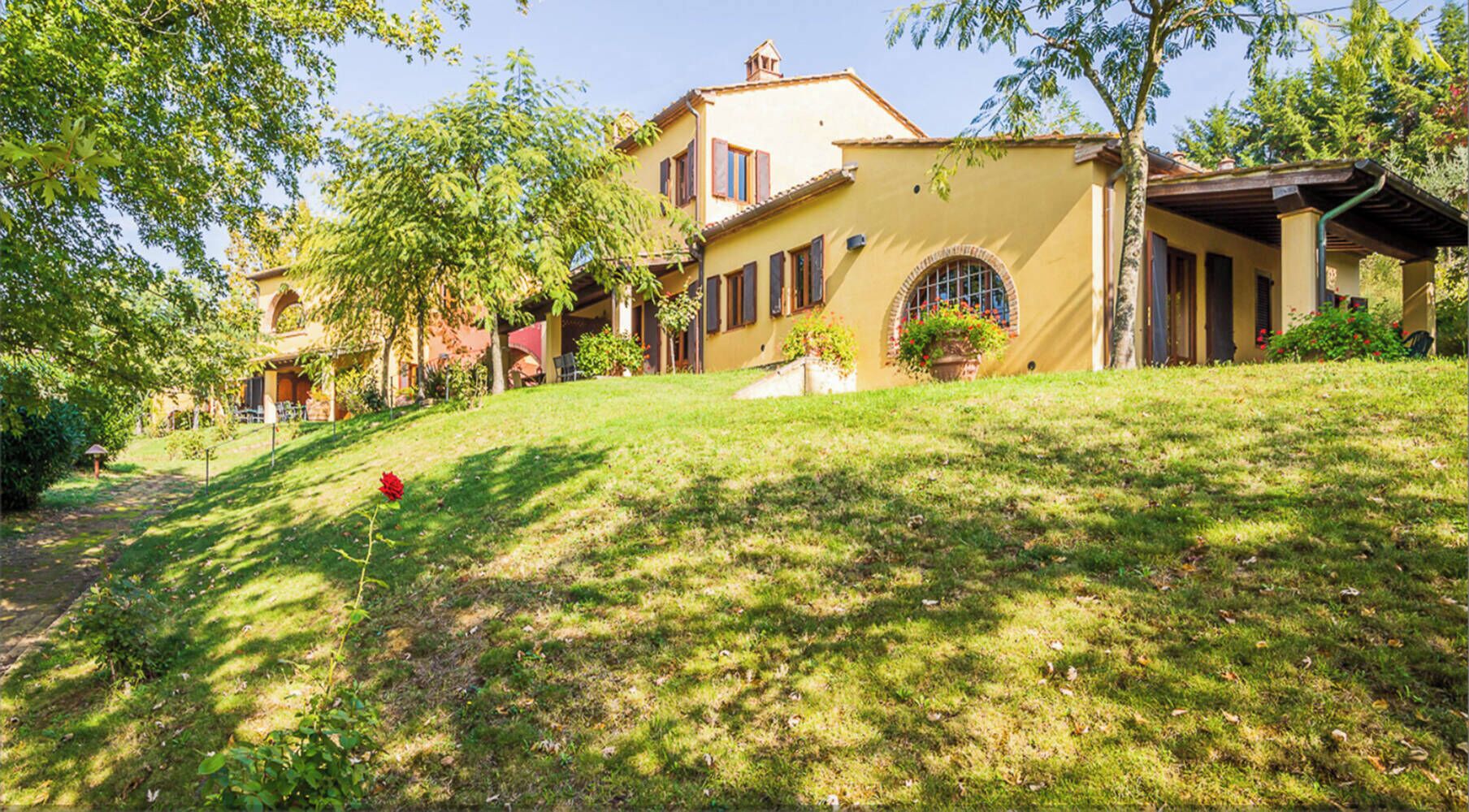 A two-story house with a sloped roof, a covered porch, and a well-maintained lawn.