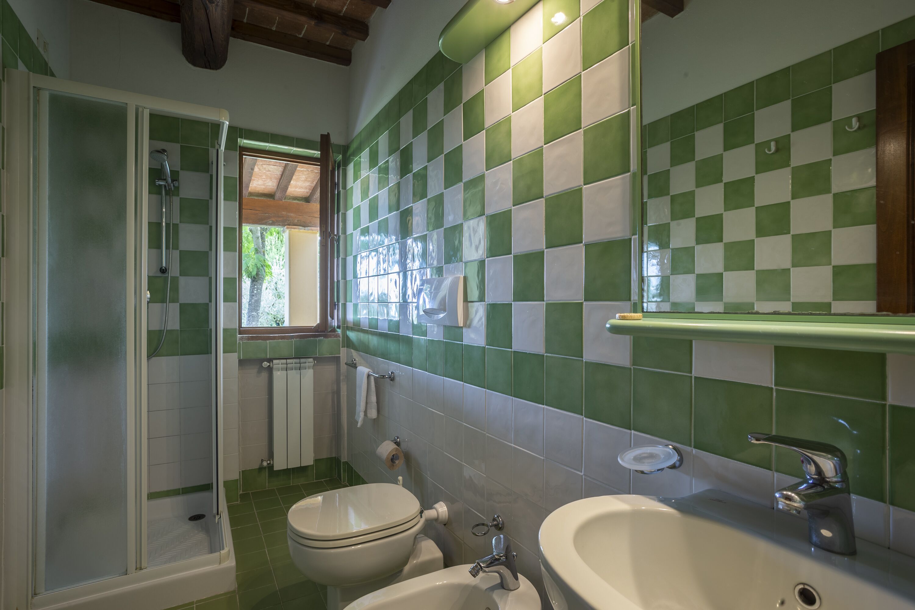 A bathroom with a shower, toilet, and sink.
