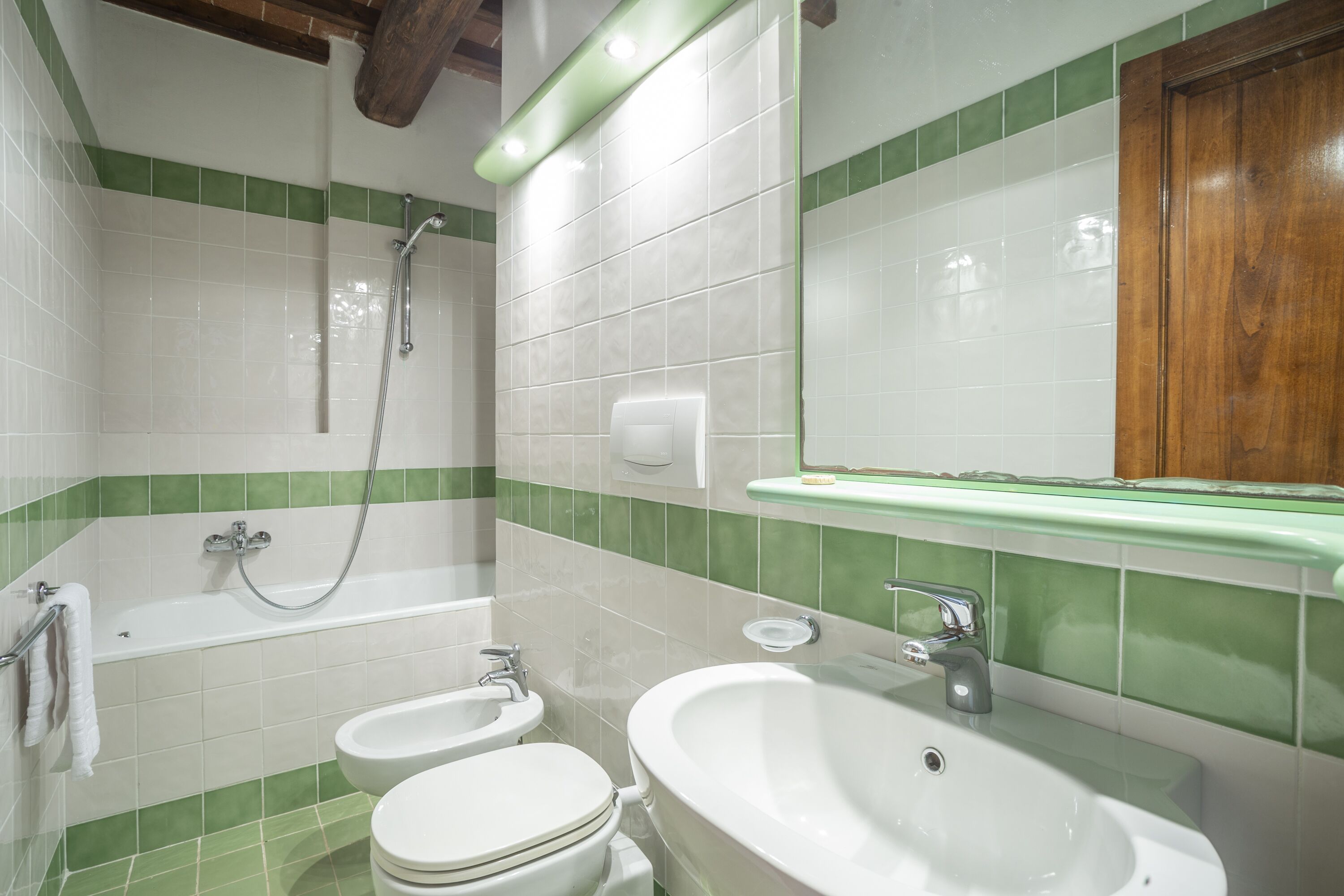 A bathroom with a bathtub, two sinks, and a toilet.