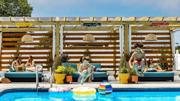 A pool area with lounge chairs and a pergola overhead. - Freebird Motor Lodge by Reverie Boutique Collection (West Yarmouth)