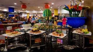 Un área de buffet con distintas estaciones de comida y un centro de mesa decorativo.