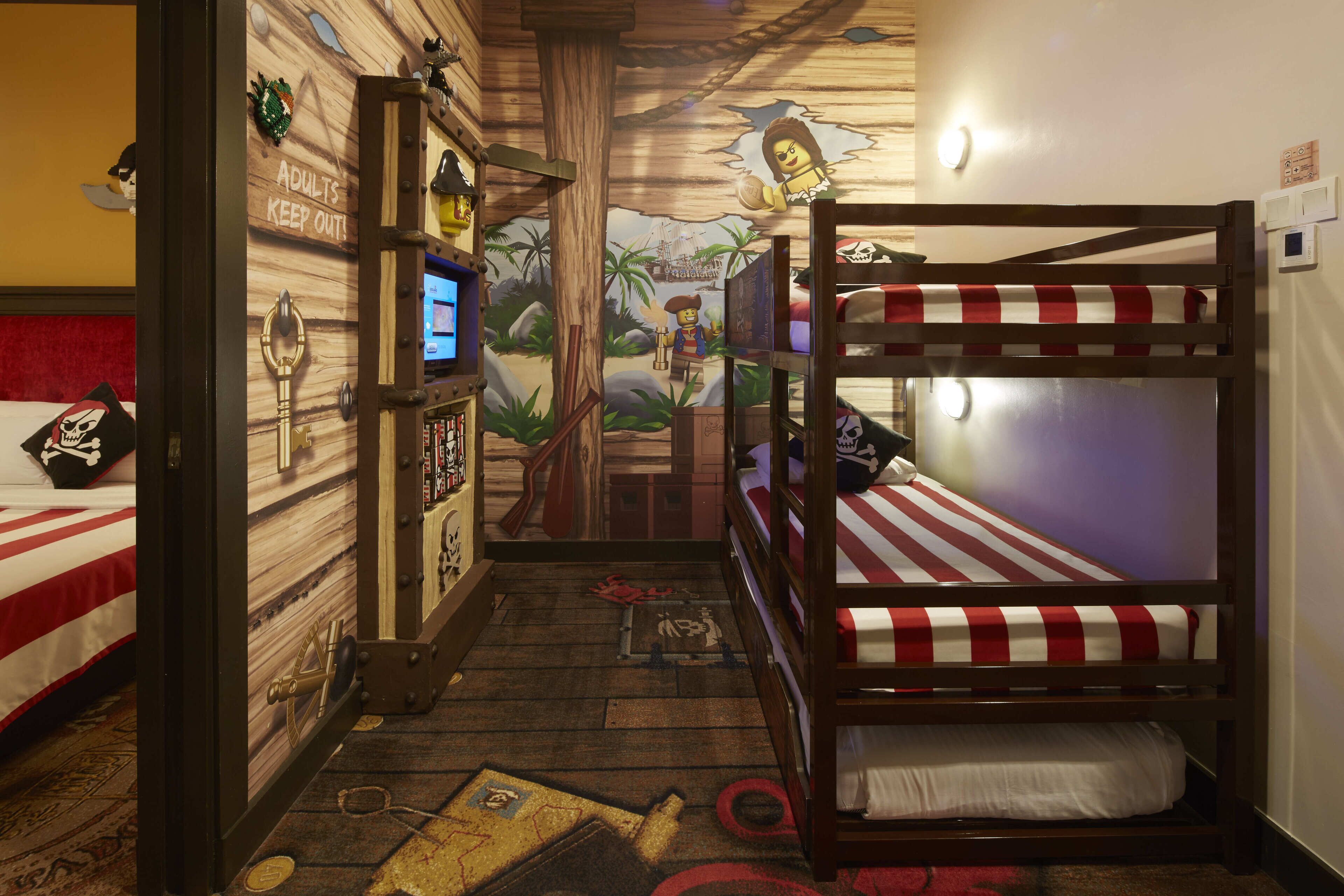 A themed room with bunk beds, a treasure chest, and a wall mural.