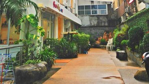 Un hotel llamado 'B&B House' con un letrero en el edificio. Se ven plantas y zonas de estar al aire libre.