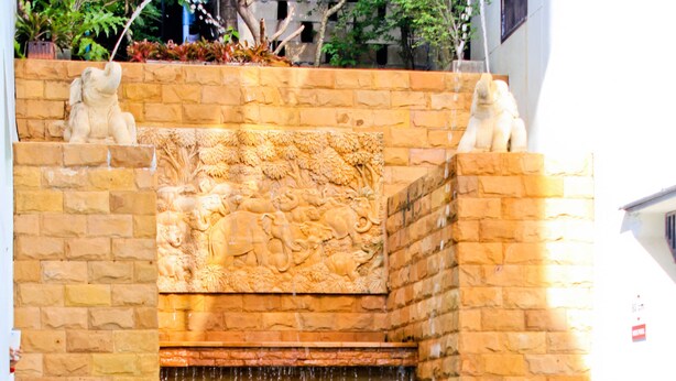 Una fuente de piedra con una cascada y una piscina en la parte inferior.