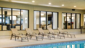 A pool area with lounge chairs and large windows. - Wingate by Wyndham Slidell/New Orleans East Area (Slidell)