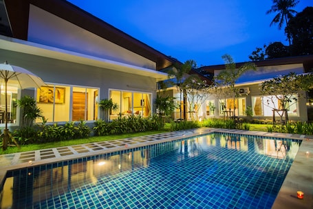 Una piscina al aire libre, sillones reclinables de piscina