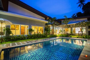 Una piscina al aire libre, sillones reclinables de piscina