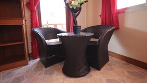 A corner room with wicker furniture, a small table, and a vase with flowers. - Lanta Nature House (Ko Lanta)