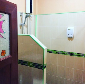 A bathroom with a shower, a hand dryer, and a soap dispenser on the wall. - Phu Lanta Life (Ko Lanta)