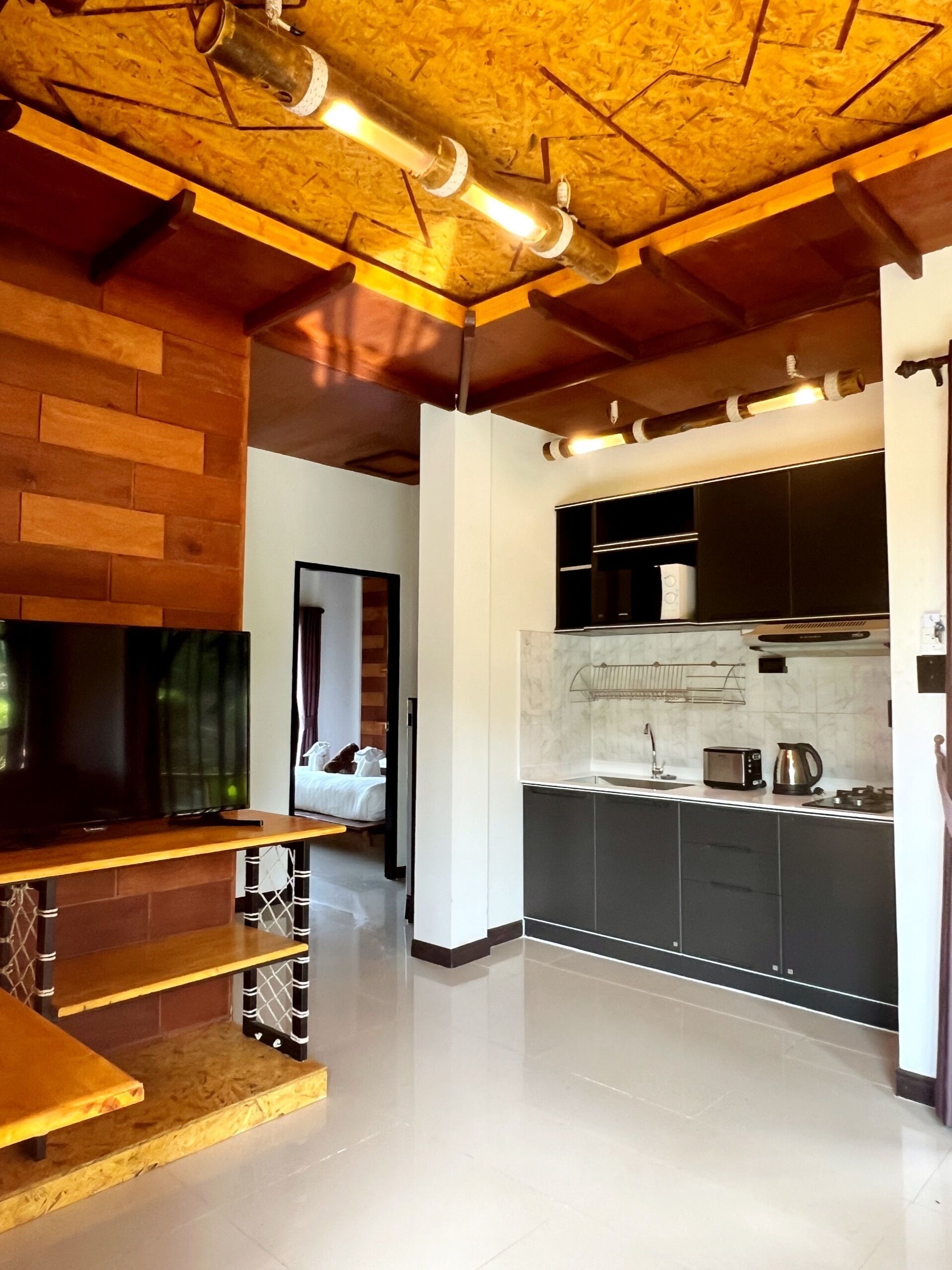 Une cuisine moderne avec un plafond en bois, des placards intégrés, un plan de travail et un grille-pain bien visible.