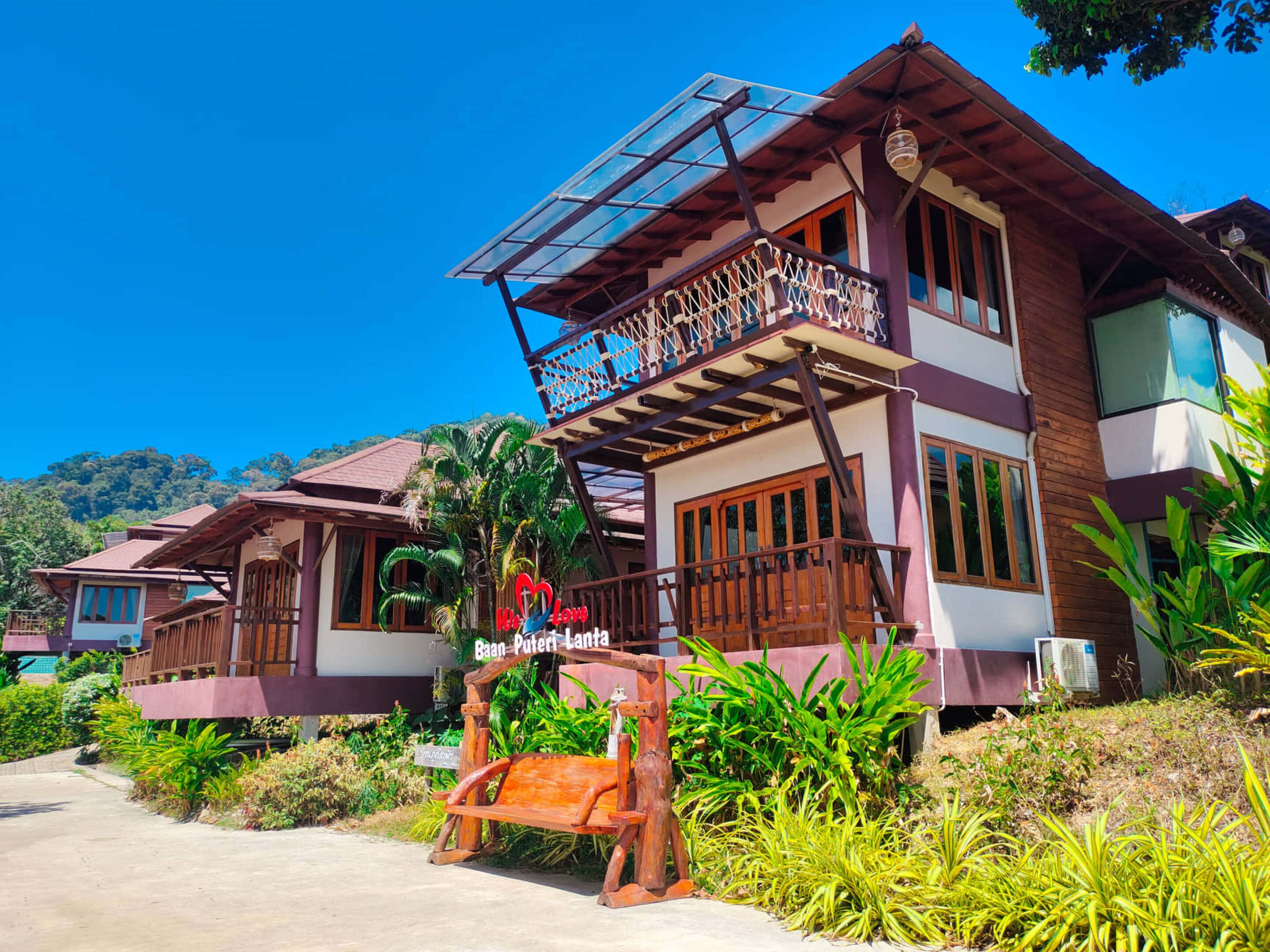 A two-story building with a balcony and a sign that reads "Baan Puteri Lanra."