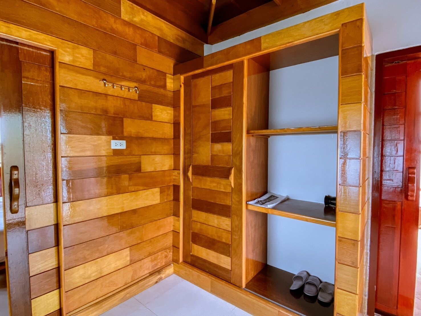 Une armoire en bois dotée de plusieurs compartiments et d’un porte-chaussures.