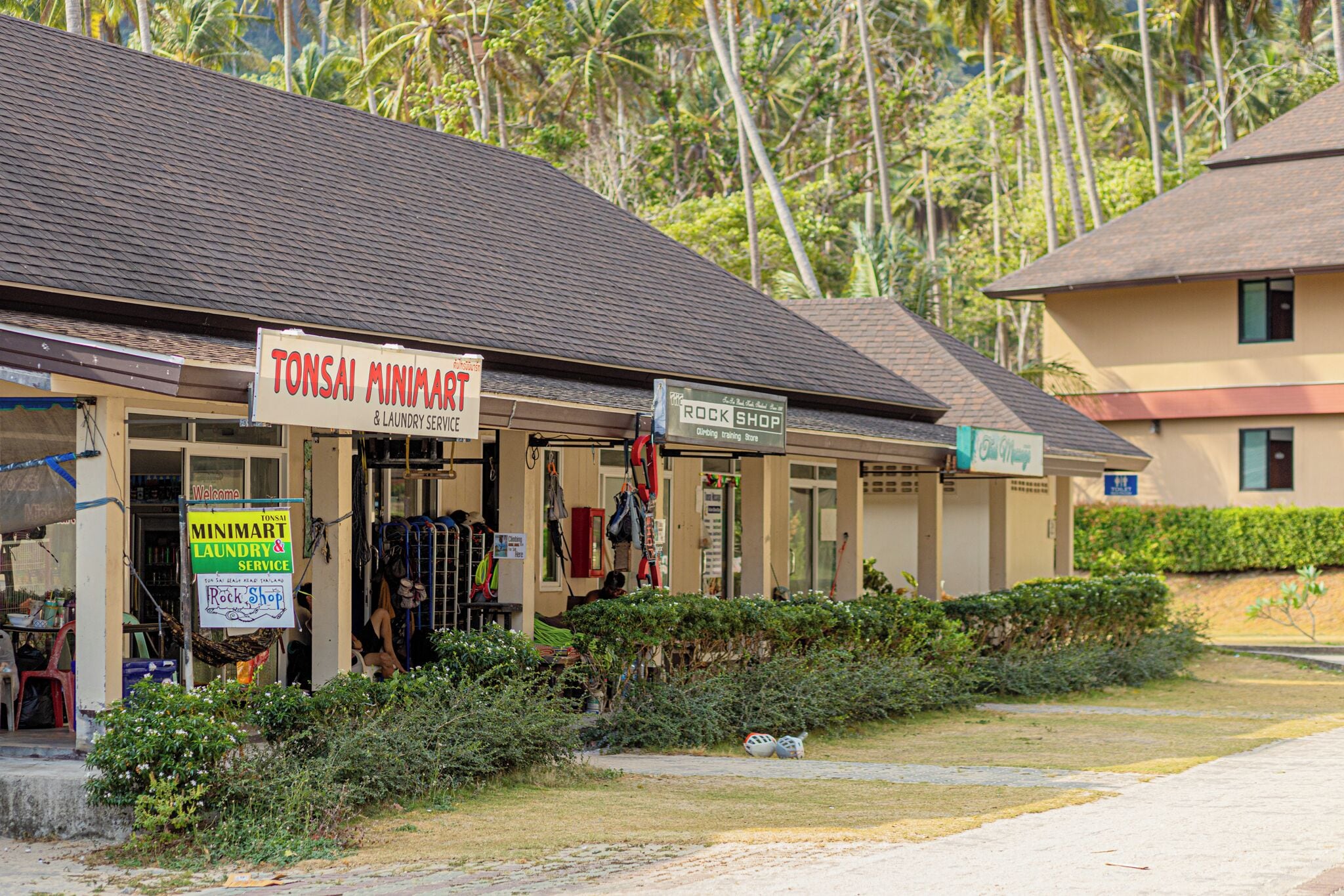 A building with signs for 'Tonsai Minimart & Laundry Service' and 'Rock Shop'.