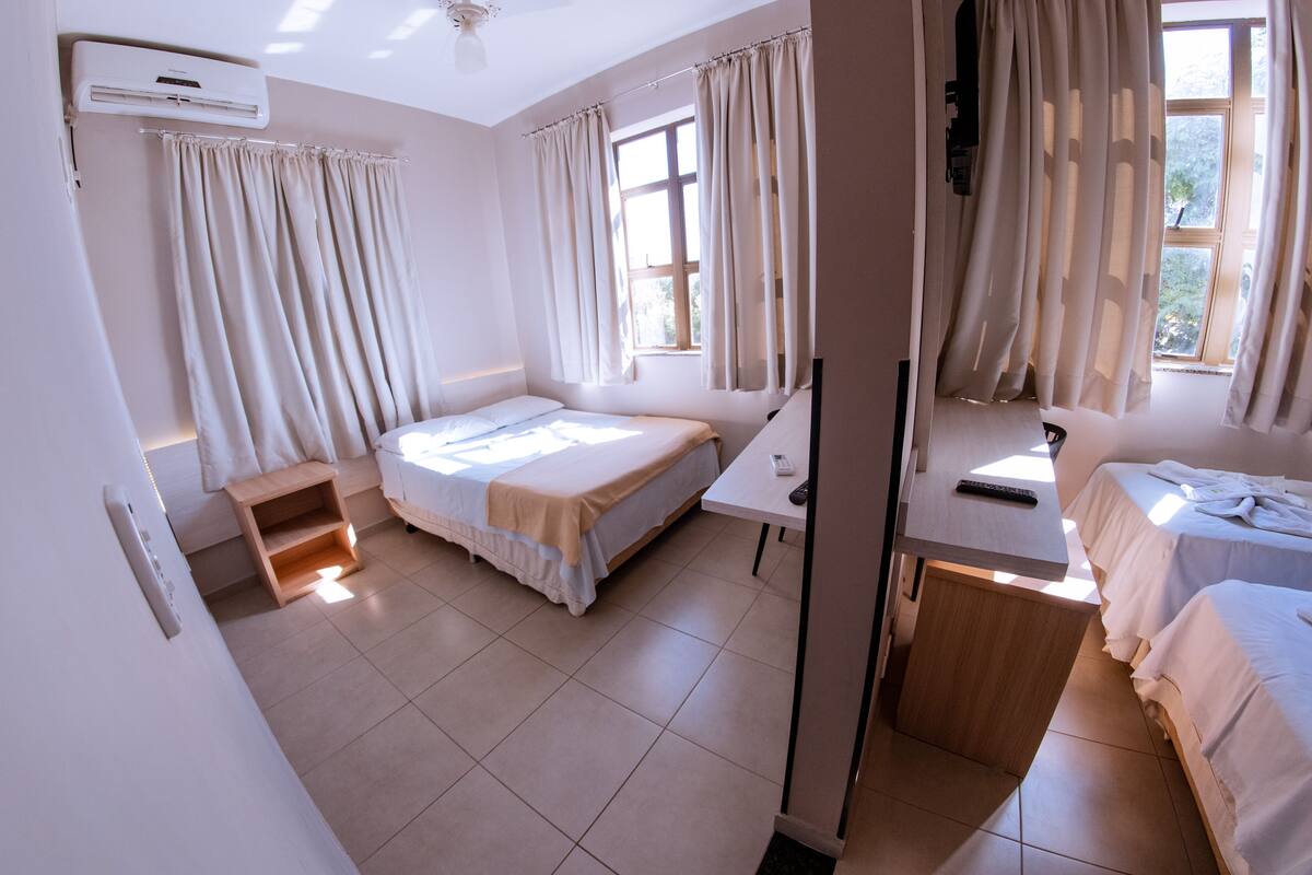 Un dormitorio con cama, escritorio y ventana.