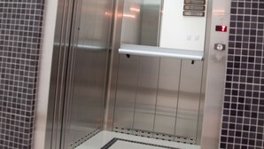 An elevator with a metallic interior, a control panel with buttons, and a tiled floor. - Roari Hotel (Cuiabá)