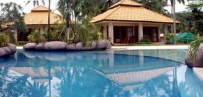 Een buitenzwembad, parasols voor strand/zwembad