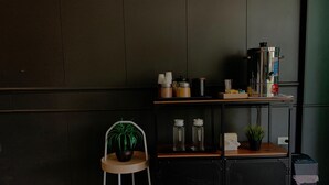 A kitchenette with a coffee machine, jars, and a small plant. - Tharapark View Hotel (Krabi)
