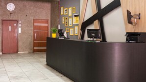 Una reception con una sveglia, certificati incorniciati e un vaso di fiori.