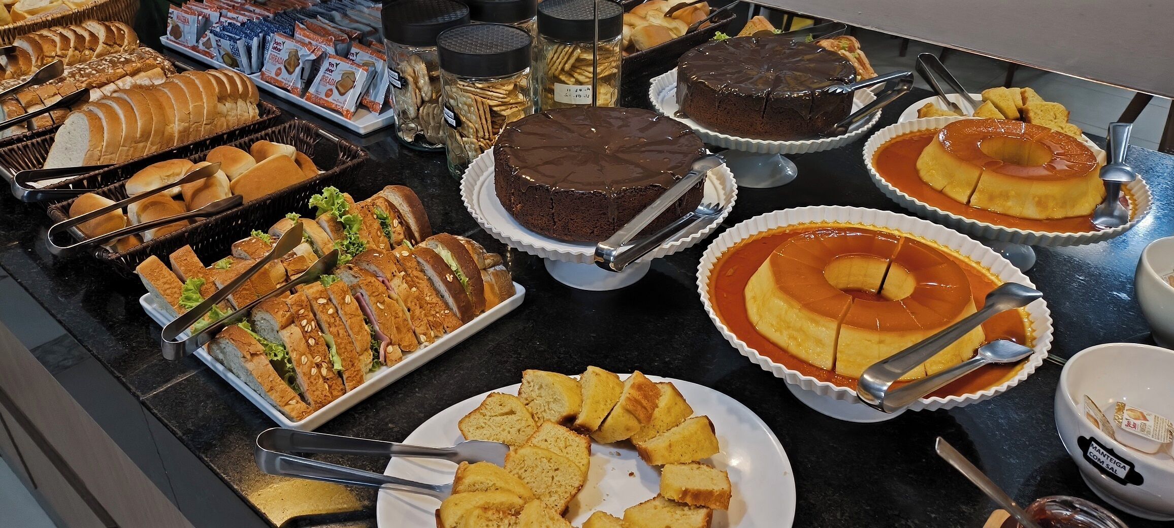 A buffet with various desserts and bread.