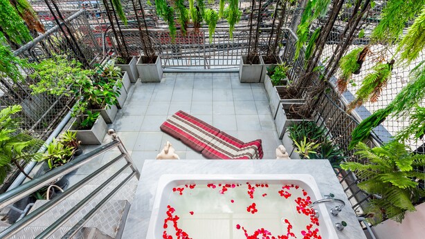A rooftop terrace with a spa tub surrounded by greenery and a red-striped rug. - The Nine Hotel at Ao Nang (Krabi)