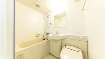 A small, compact bathroom with a bathtub, sink, and toilet.