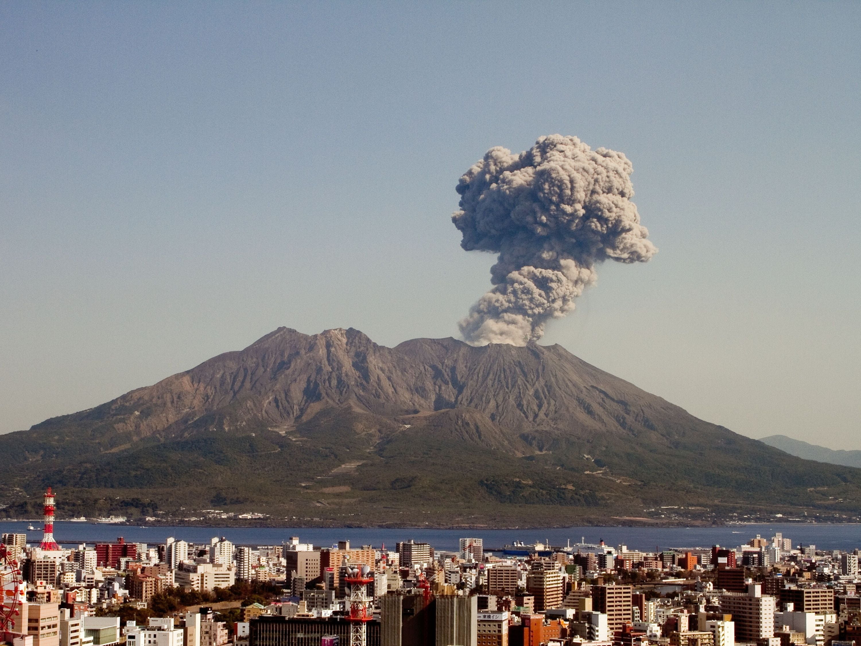 A cityscape with a volcano in the background.