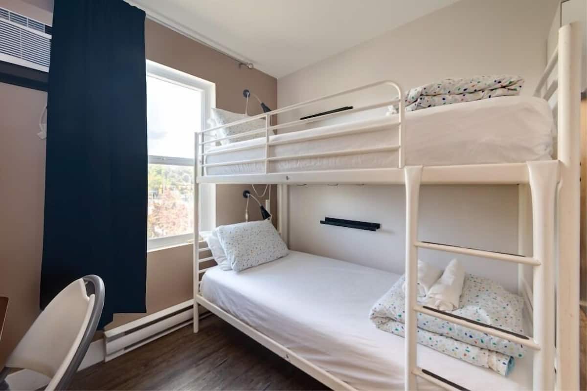 Habitación con literas, escritorio y ventana.