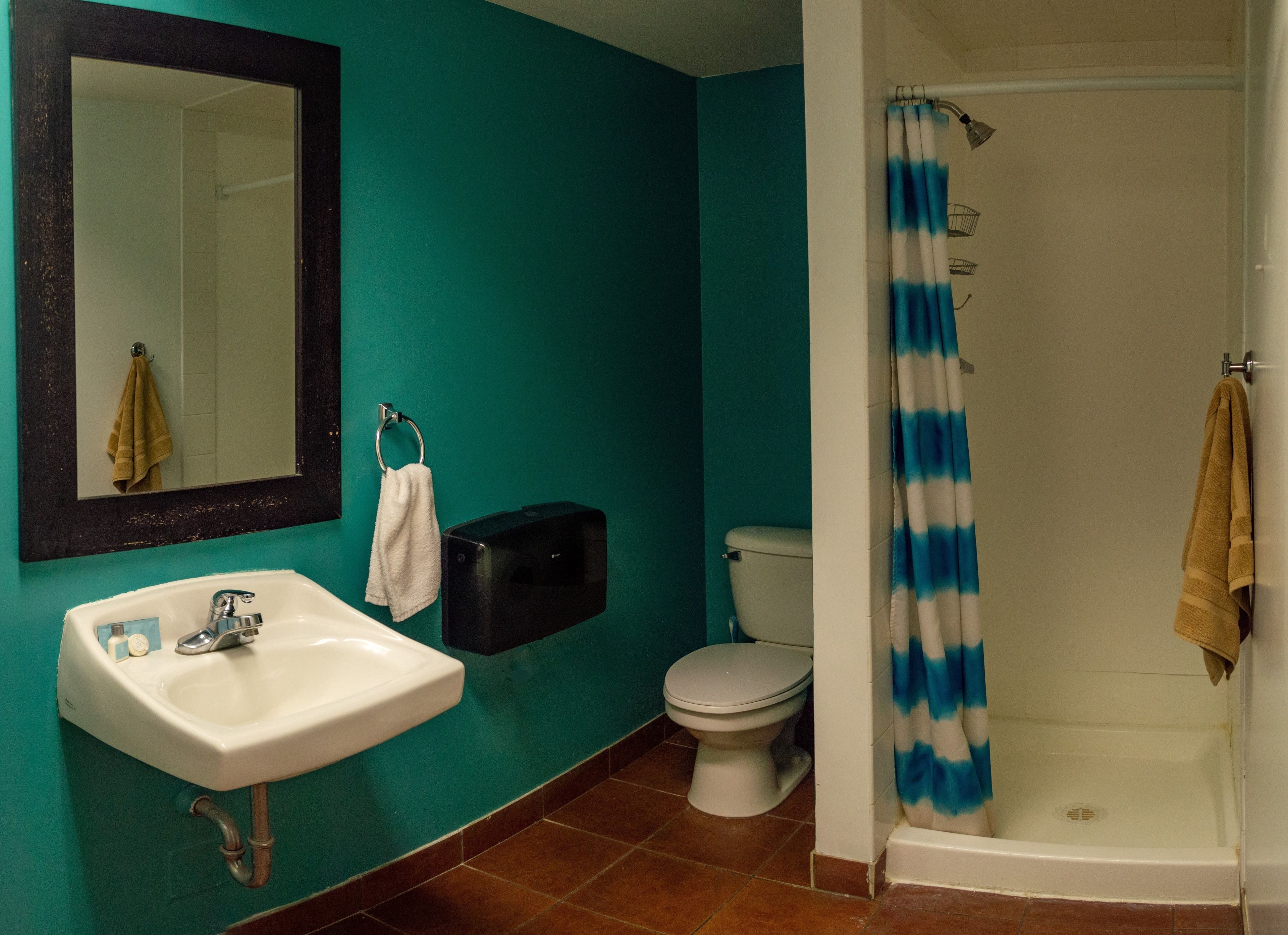 A bathroom with a sink, toilet, and shower.