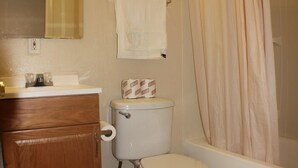 A bathroom with a toilet, sink, and bathtub. - International Casa (Oakland)
