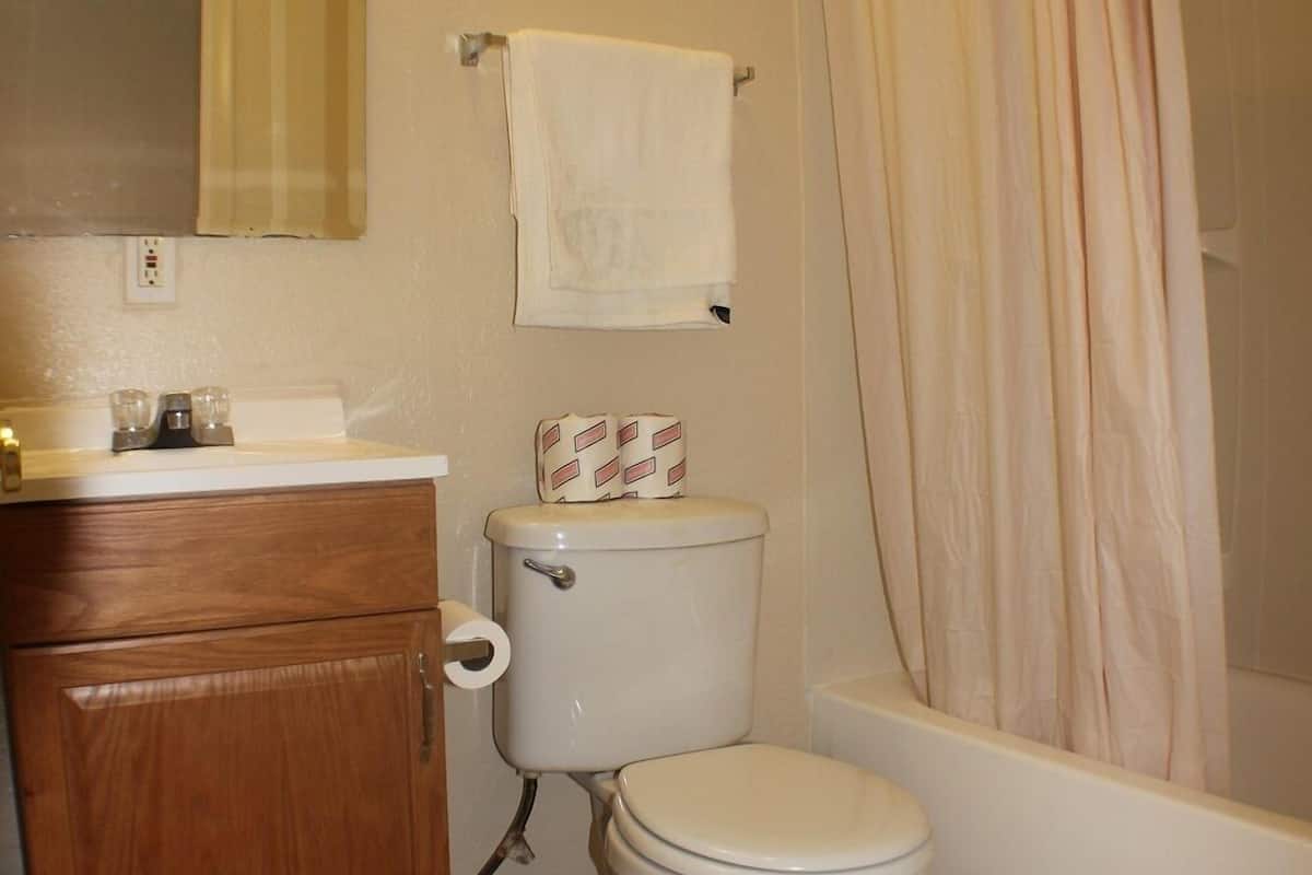 A bathroom with a toilet, sink, and bathtub.