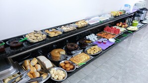 A buffet with various food items including bread, pastries, fruits, and desserts. - Hotel Almanara (Cuiabá)