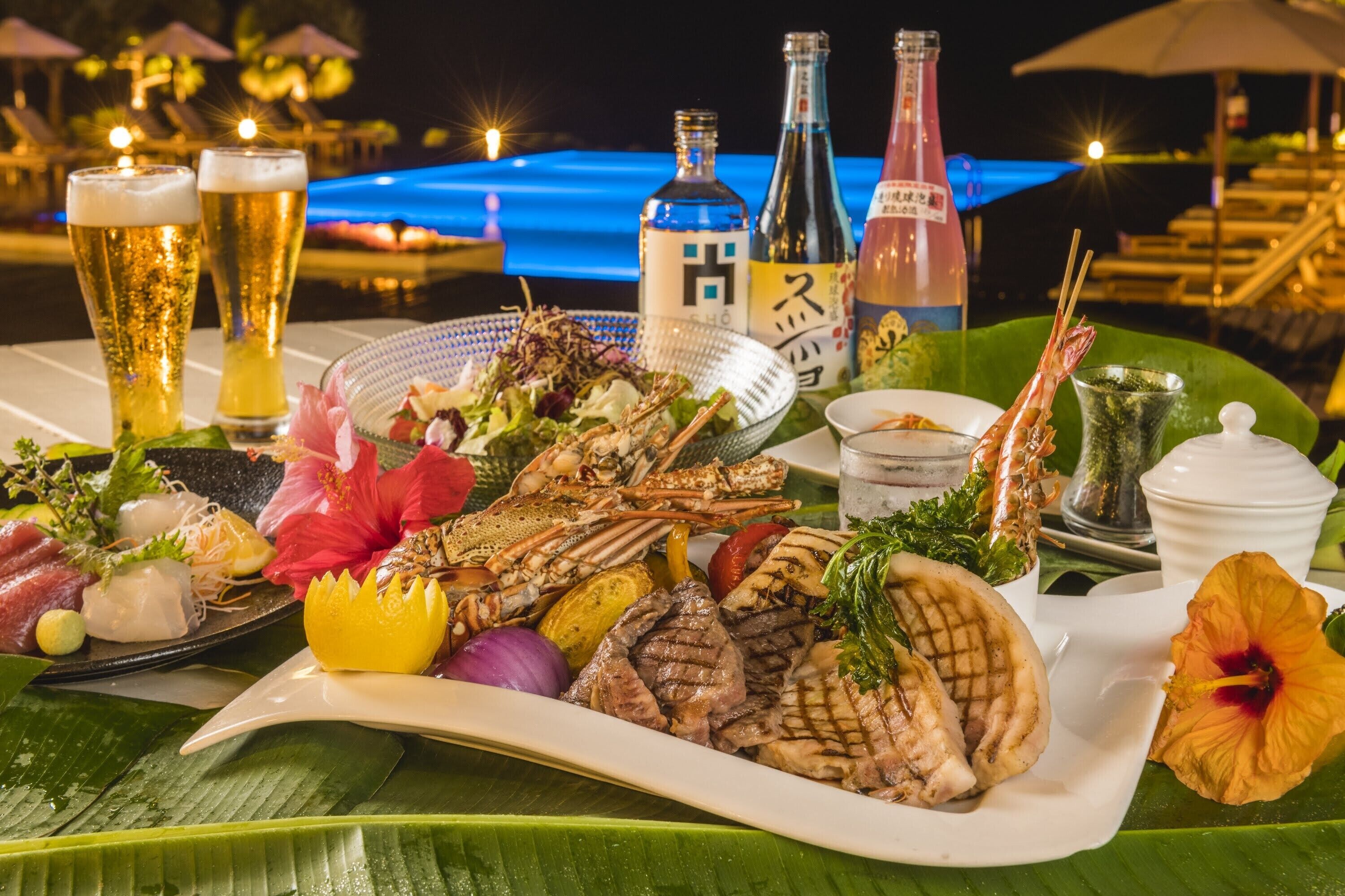 A seafood platter with grilled items and a drink selection on a table by a poolside setting.