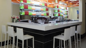 A bar area with a modern design, featuring a central counter and multiple seating options. - Puerto Mercado Hotel (Montevideo)