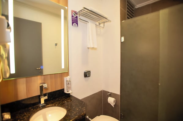 A bathroom with a sink, mirror, towel rack, and toilet.