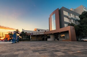 Un hotel de diseño moderno, con una entrada destacada y un cielo despejado al fondo.