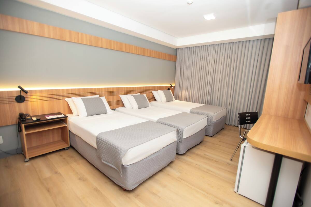 Una habitación de hotel moderna con dos camas, un escritorio y una silla.
