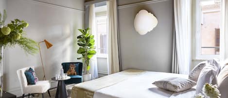 Deluxe kamer | Luxe beddengoed, een minibar, een kluis op de kamer, een bureau