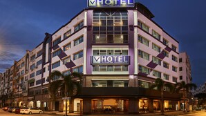 A multi-story hotel with a prominent 'HOTEL' sign, large windows, and a well-lit entrance. - V Hotel (Kuala Lumpur)