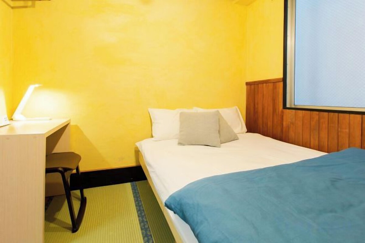 A hotel room with a bed, a desk, and a chair.