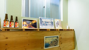 A wooden shelf with three bottles, two framed pictures, and a small framed picture.