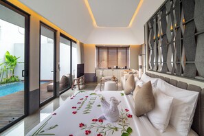Une chambre d’hôtel moderne dotée d’un grand lit, offrant une vue sur une piscine, comprenant un coin repas et une cuisine.