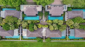 A modern hotel with a central swimming pool, surrounded by lush greenery and multiple guest rooms. - Javana Royal Villas (Keroboken Kelod)